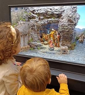 Dos niños miran un belén de la exposición de Baluarte en la navidad 2025